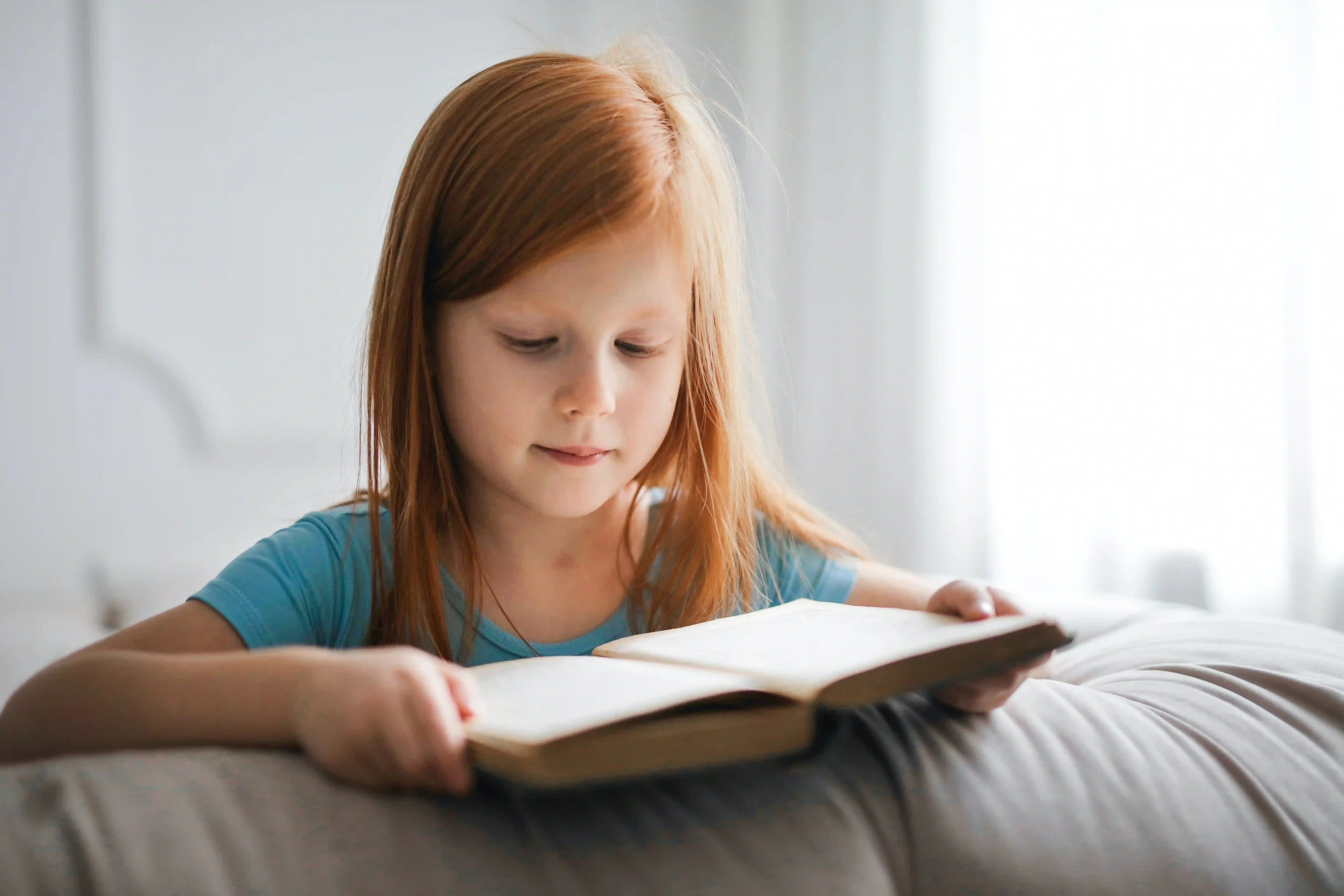 Bambina che legge un libro: lavoro sui disturbi dell'apprendimento.